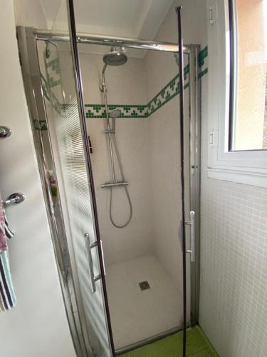 eine Dusche mit Glastür im Bad in der Unterkunft Chambre Serenity in Brignais