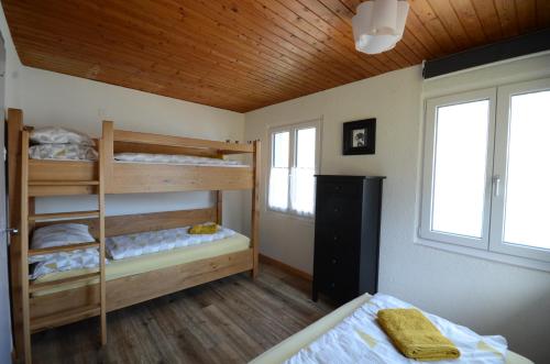 a bedroom with two bunk beds and two windows at Lake House in Bönigen