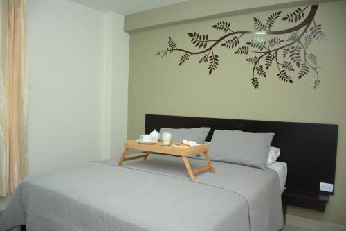 a bedroom with a bed with a table on it at Villa Santa in Chiclayo