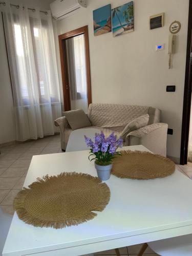 un soggiorno con tavolo bianco e fiori di CASA BRUNA a Chioggia