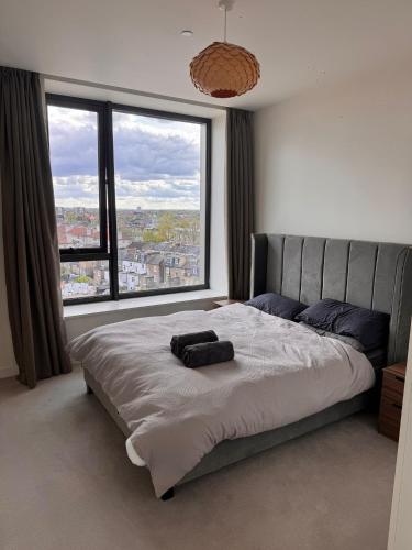 a bedroom with a large bed with a large window at Luxury 2 Beds Apartment in White city in London