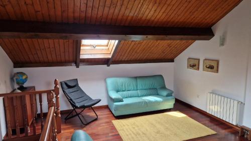 a living room with a blue couch and a chair at Chalet Adosado con jardín in Cóbreces