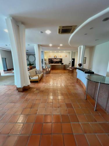 a large living room with a couch and a table at Hotel Violeta in Guarapari