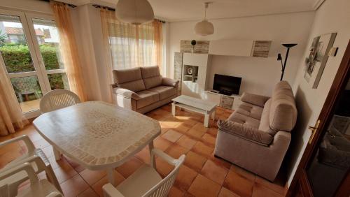 a living room with a table and chairs at Chalet Adosado con jardín in Cóbreces