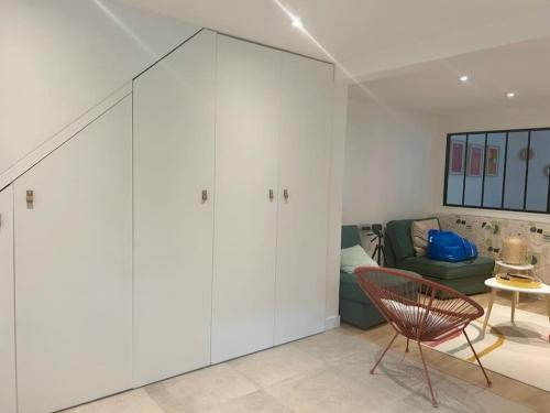 - un salon avec des placards blancs et un canapé vert dans l'établissement Nice new apartment with direct access a big garden, à Saint-Germain-en-Laye