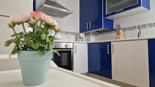 a vase with pink flowers sitting on a counter in a kitchen at Chalet Adosado con jardín in Cóbreces