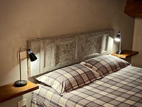 Schlafzimmer mit einem Bett mit einem großen Kopfteil aus Holz in der Unterkunft Il Viaggiatore Appartamento in Anagni