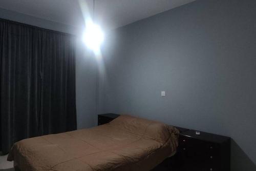 パトラにあるΒίλα στην Πάτραのベッド1台付きの部屋、壁に照明が付いています。