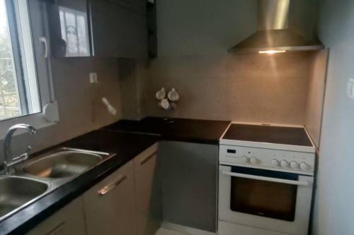 a kitchen with a sink and a stove at Βίλα στην Πάτρα in Patra