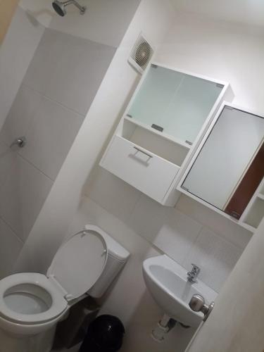 ein weißes Bad mit einem WC und einem Waschbecken in der Unterkunft Moderno y acogedor apartamento con vista al jardin in Lima