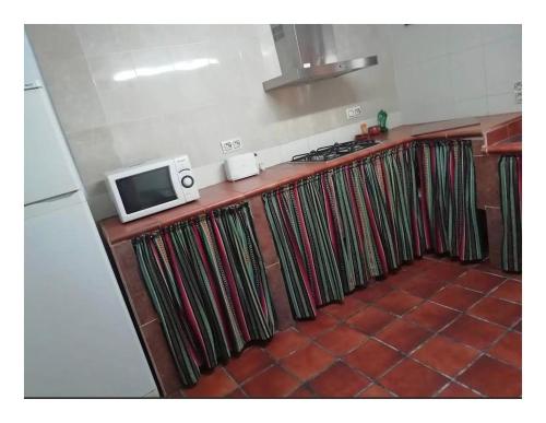 a kitchen with a stove and a microwave at Casa Rural El Abejorro in Alcalá del Júcar