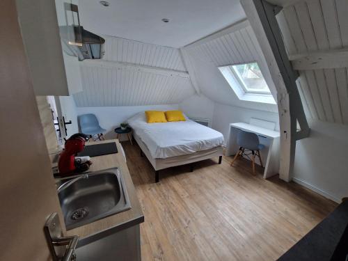 een kleine slaapkamer met een bed en een wastafel bij Castle room in Pierrefonds