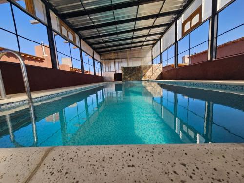 a swimming pool with blue water in a building at La Comarca in Uspallata