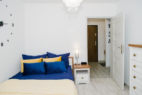 a bedroom with blue and yellow pillows on a bed at Apartament Reda in Reda