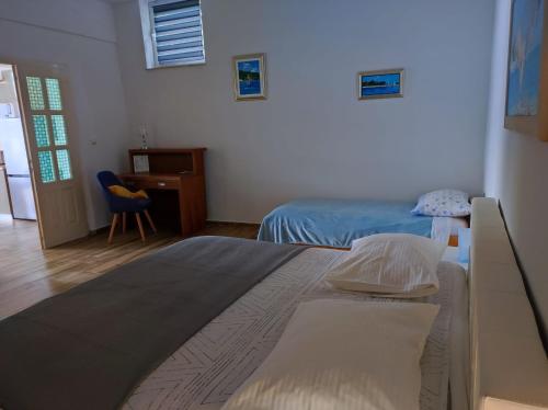 1 dormitorio con 2 camas, escritorio y silla en Apartment Mareta in Viganj, en Viganj