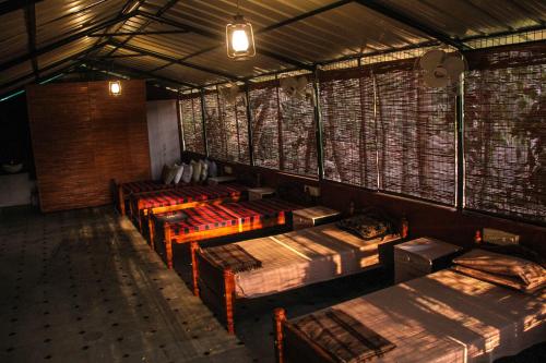 a room with a bunch of beds in it at Rancho Farmstay in Sultan Bathery