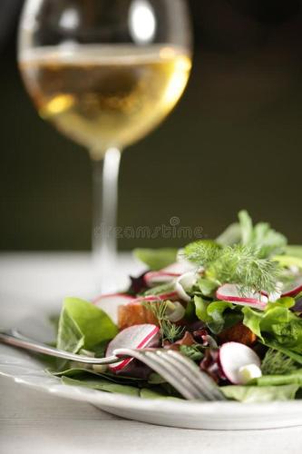 a plate of salad with a glass of wine at "Les Chacobins" - appart'étape avec Garage Vélos in La Réole