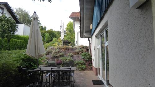 a patio with an umbrella and a table with an umbrella at Landleben - Ferienhaus 1 in Fritzlar