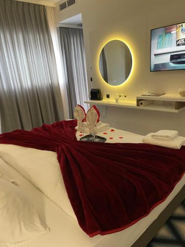 a hotel room with a bed with a flower on it at Swiss Plus Hotel in Bihać