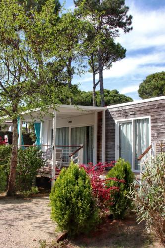 a house with flowers in front of it at Dune Prestige & Chalets in Bibione