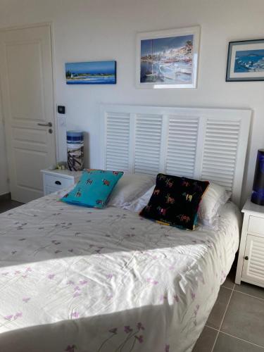un lit avec deux oreillers dessus dans une chambre dans l'établissement Charmant F3 vue mer avec piscine, à Bandol