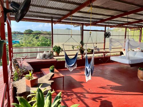 a porch with a hammock and a swing at Villas Jacquelina in Quepos