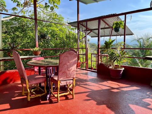 a patio with a table and chairs on a balcony at Villas Jacquelina in Quepos