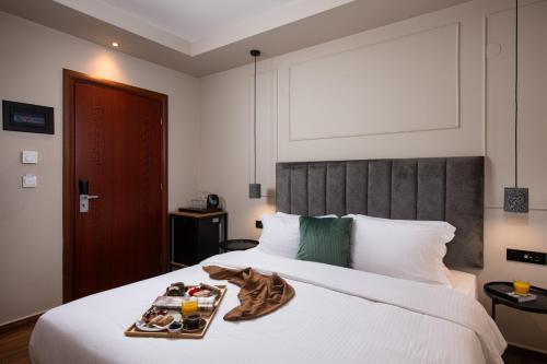 a hotel room with a tray of food on a bed at Hotel Naiades in Órma