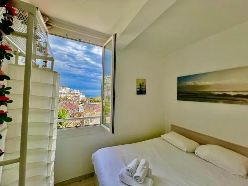 ein Schlafzimmer mit einem Bett und einem großen Fenster in der Unterkunft T2 Splendid View Near Monaco in Beausoleil
