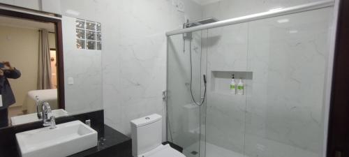 a bathroom with a shower and a toilet and a sink at Pousada da Paz in Curitiba