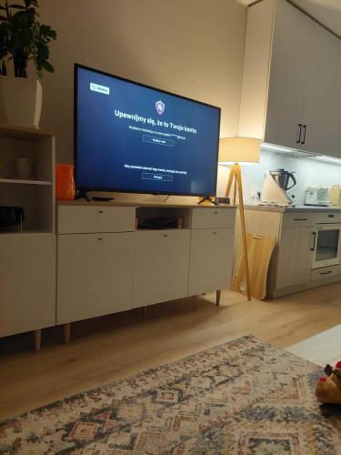 uma sala de estar com uma grande televisão de ecrã plano num armário em Apartament Ząbki em Zabki
