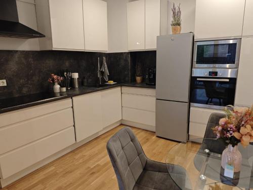 a kitchen with white cabinets and a glass table at *1A Lage/Top Anbindung/4 Pers./Tiefgarage/Smart-TV* in Cologne