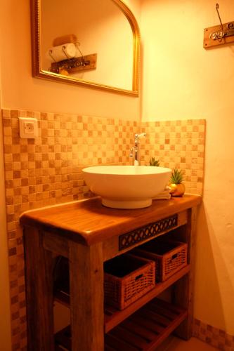 ein Bad mit einem Waschbecken und einem Spiegel in der Unterkunft La Bastide Portoly Gîte "Le Pigeonnier" in Penne-dʼAgenais