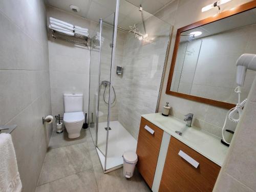 ein Bad mit einer Dusche, einem WC und einem Waschbecken in der Unterkunft Apartamentos Playa De Covachos in Soto de la Marina
