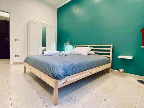 Cama en habitación con pared verde en Cinque Terre Casa Gina La Spezia en La Spezia