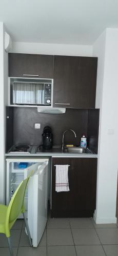 a small kitchen with a sink and a microwave at Studio in Avignon