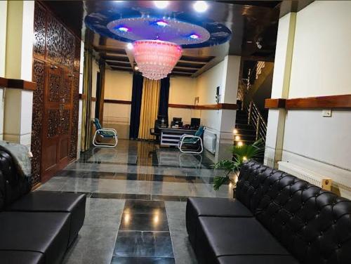 a lobby with a couch and a chandelier at LeGrand Hotel & Resort in Swat