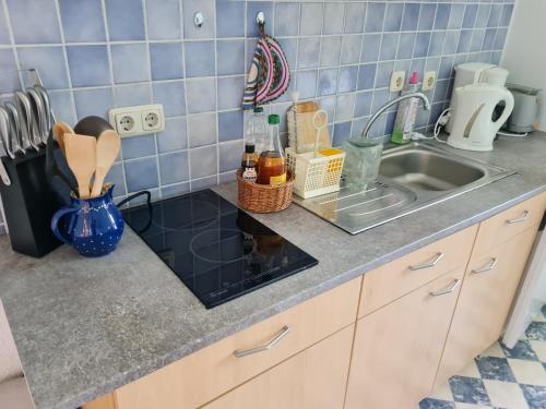 a kitchen counter with a sink and blue tiles at Ferienwohnung Erzgebirgsblick in Bernsbach