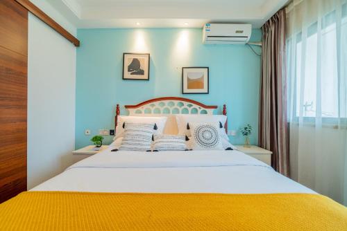 a bedroom with a large bed with blue walls at Yue Ke Apartment - Changbin Road Branch in Chongqing