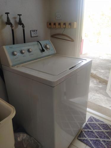 uma máquina de lavar roupa com um lavatório na casa de banho em Cozy Country Home em Saint Philip