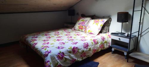 a bedroom with a bed with a floral bedspread at Bienvenue chez vous in Le Puy en Velay