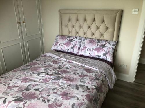 a bedroom with a bed with a pink floral bedspread at Bungalow in the countryside in Roscommon