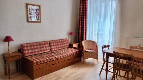 uma sala de estar com um sofá e uma mesa em Résidence Les Iles Britanniques em La Bourboule