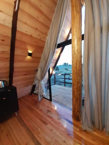 a room with a large window and a wooden floor at Fazenda Invernada Grande Turismo Rural in Bom Jardim da Serra