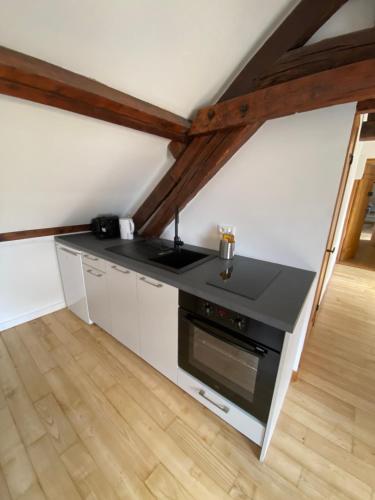 - une cuisine mansardée avec une cuisinière dans l'établissement L'enclave intime, à Amiens