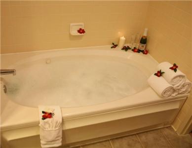 a bathroom with a bath tub with towels on it at Rocklin Park Hotel in Rocklin