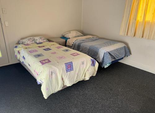 two beds in a small room with at Tauranga Bungalow in Tauranga