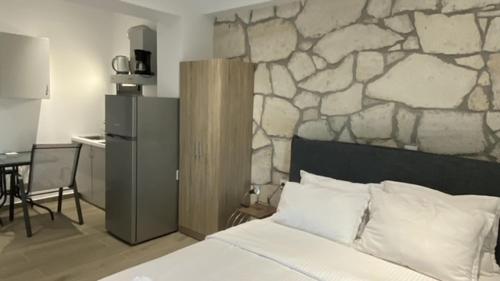 a bedroom with a stone wall behind a bed at Afytos sea view in Afitos