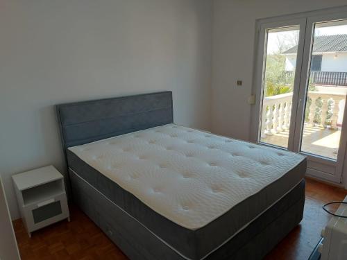 1 cama en un dormitorio con ventana grande en Apartmani Manda Nin - Sabunike, en Nin