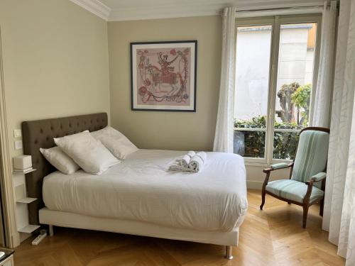 a bedroom with a bed with a cat laying on it at La Villa d'Auteuil in Paris